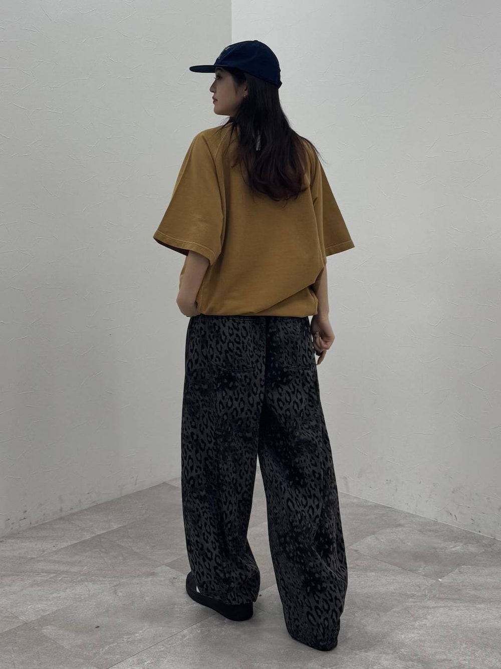 ブラック系のデニムパンツ、イエロー系のTシャツ/カットソー、ブルー系のキャップを着用したレディースの春コーディネートの3枚目の写真