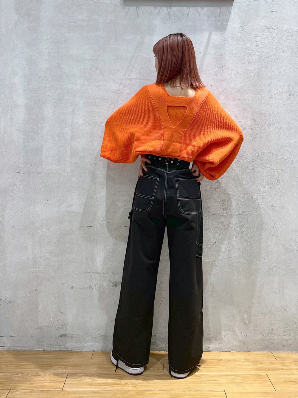 ブラック系のその他パンツ、オレンジ系のニット/セーターを着用したレディースの冬コーディネートの2枚目の写真