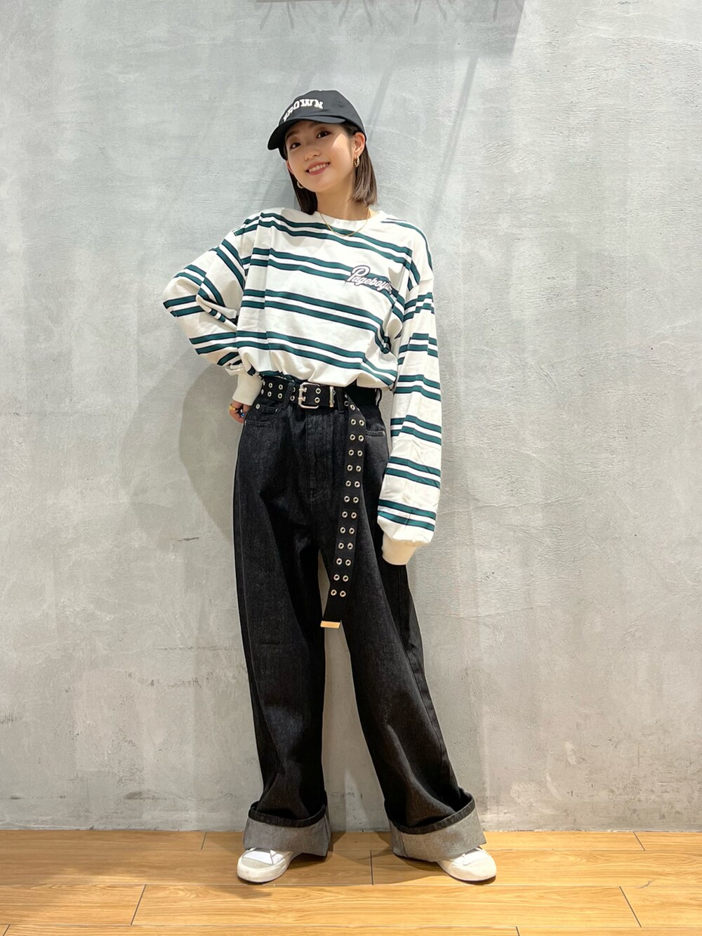 ブラック系のデニムパンツ、ホワイト系のTシャツ/カットソー、ホワイト系のスニーカーを着用したレディースの秋コーディネートの4枚目の写真