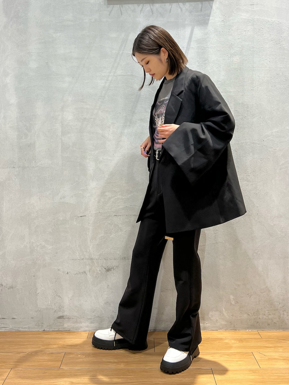 ブラック系のスラックス、ブラック系のテーラードジャケット、グレー系のTシャツ/カットソーを着用したレディースの秋コーディネートの2枚目の写真