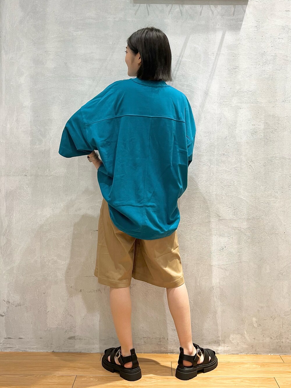 ブラック系のサンダル、ブルー系のTシャツ/カットソー、ベージュ系のその他パンツを着用したレディースの夏コーディネートの3枚目の写真