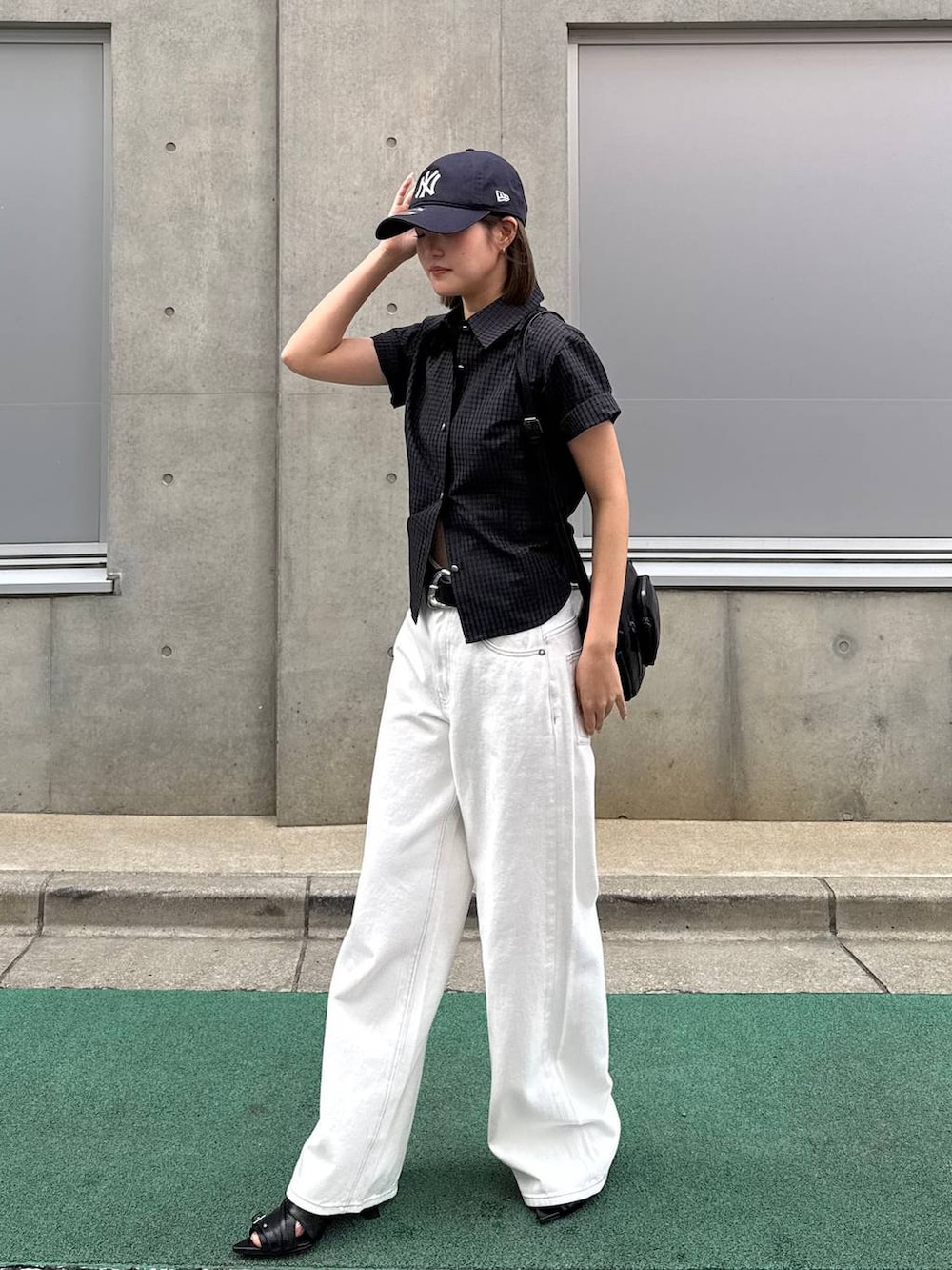 ホワイト系のデニムパンツ、ブラック系のショルダーバッグ、ブラック系のサンダルを着用したレディースの春コーディネートの2枚目の写真