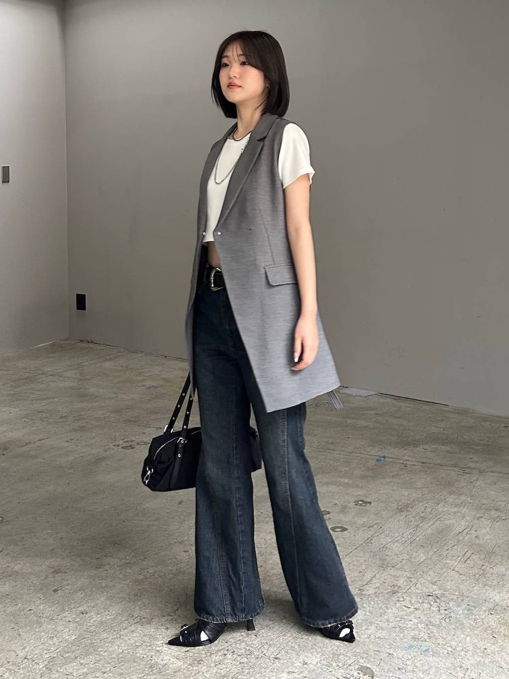 ブルー系のデニムパンツ、ブラック系のサンダル、グレー系のテーラードジャケットを着用したレディースの春コーディネートの5枚目の写真