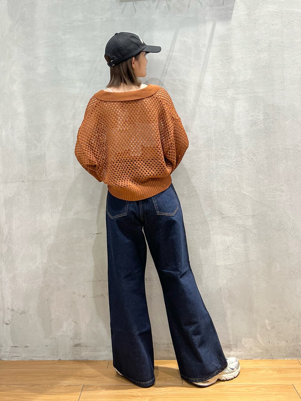 ブルー系のデニムパンツ、ブラウン系のニット/セーター、ホワイト系のキャミソールを着用したレディースの夏コーディネートの3枚目の写真