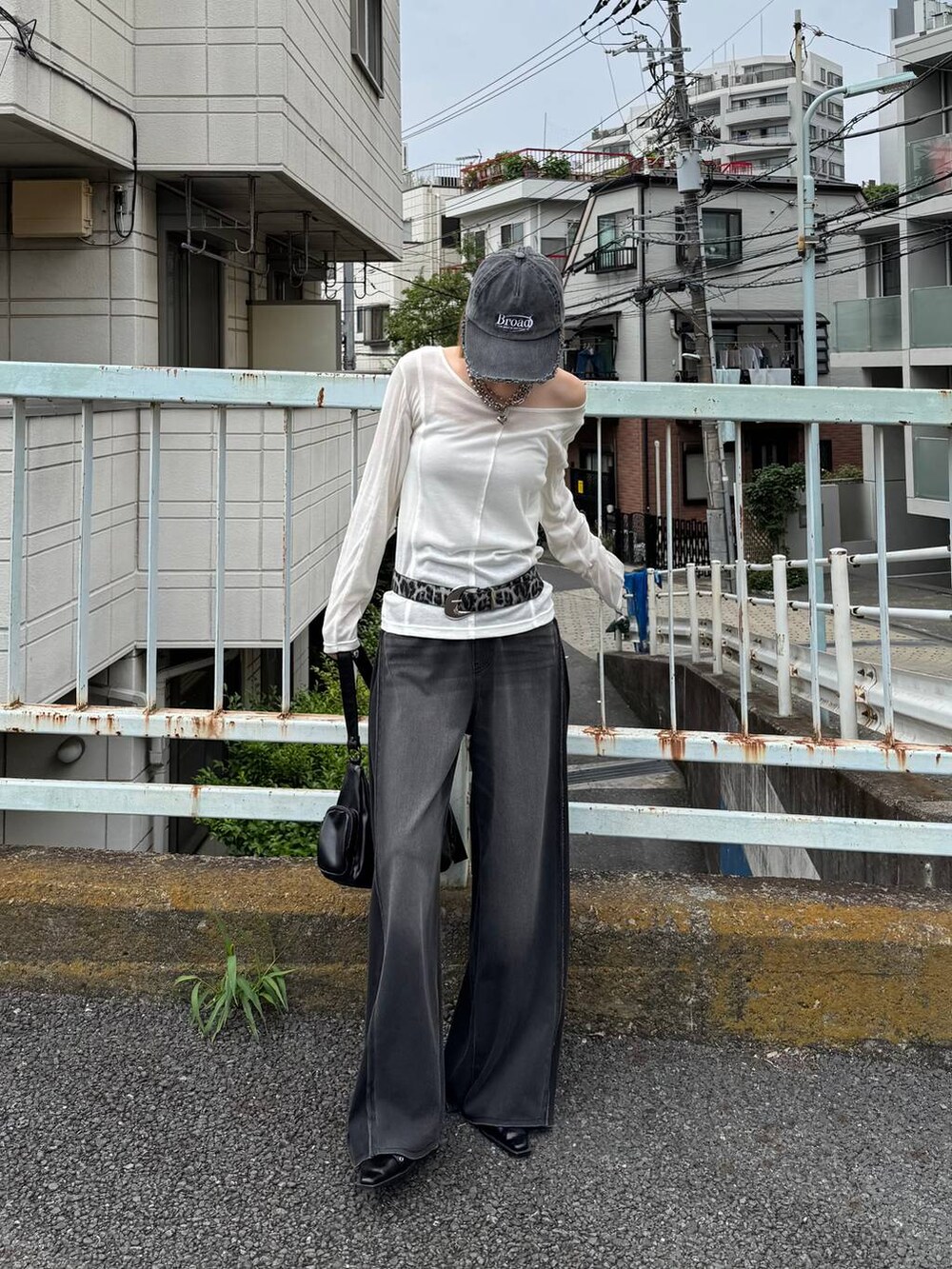 ブラック系のデニムパンツ、ブラック系のショルダーバッグ、ブラック系のキャップを着用したレディースの夏コーディネートの4枚目の写真