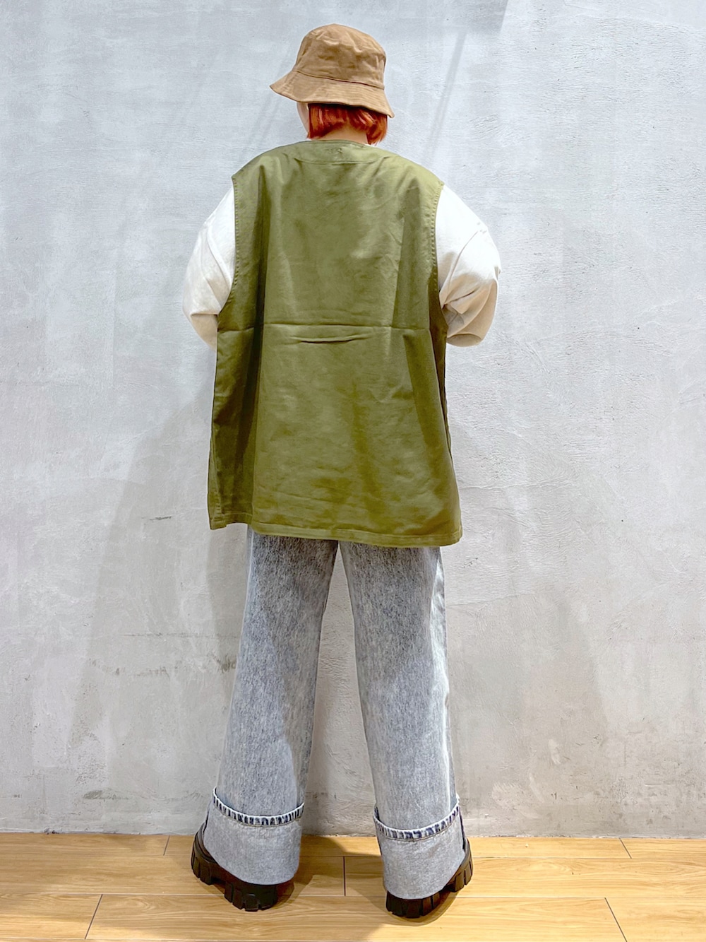 ブルー系のデニムパンツ、グリーン系のベスト、ベージュ系のスウェットを着用したレディースの秋コーディネートの4枚目の写真