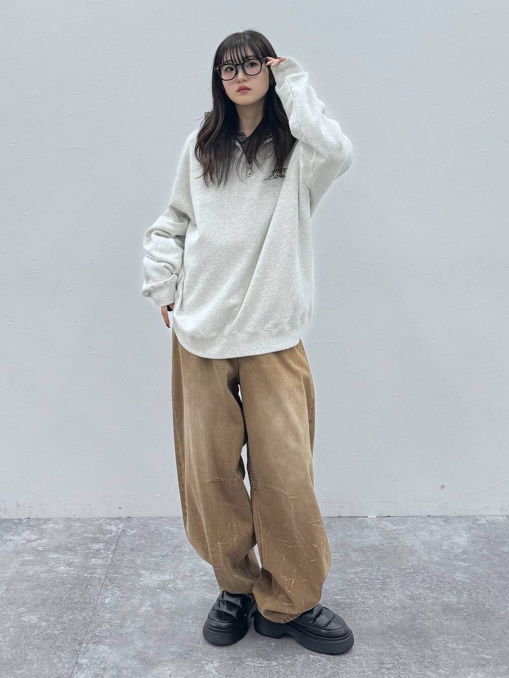 ブラック系のスリッポン、ベージュ系のデニムパンツ、グレー系のスウェットを着用したレディースの冬コーディネートの2枚目の写真