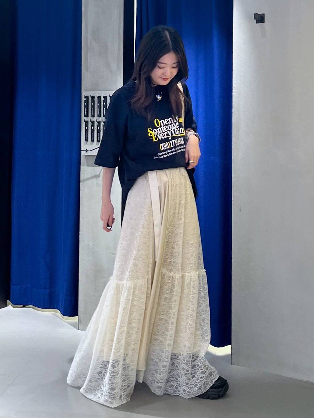 ブラック系のスニーカー、ベージュ系のショルダーバッグ、ブルー系のTシャツ/カットソーを着用したレディースの夏コーディネートの2枚目の写真