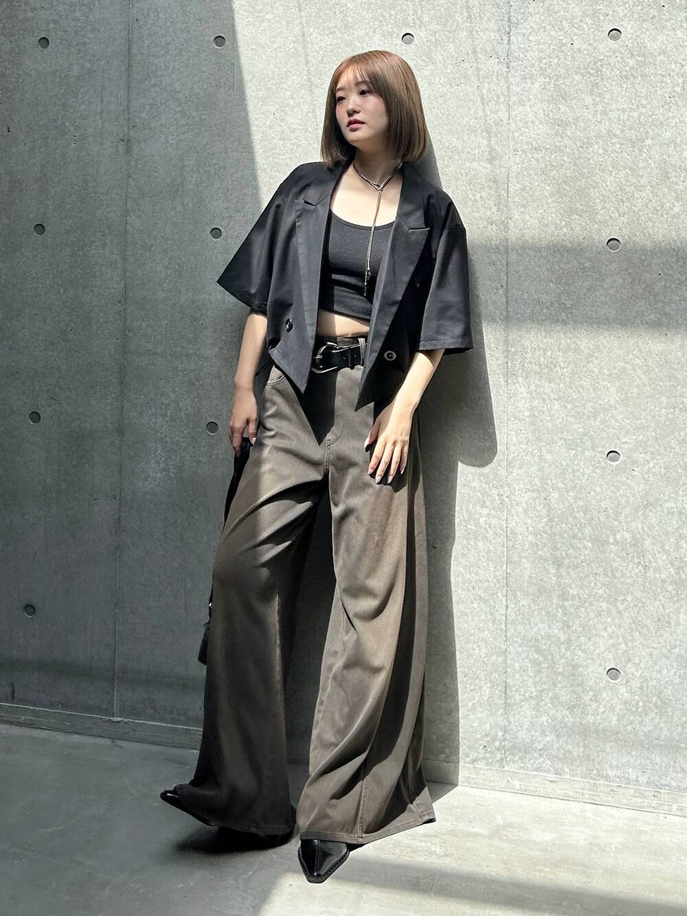 ブラック系のデニムパンツ、ブラック系のキャミソール、ブラック系のショルダーバッグを着用したレディースの夏コーディネートの5枚目の写真