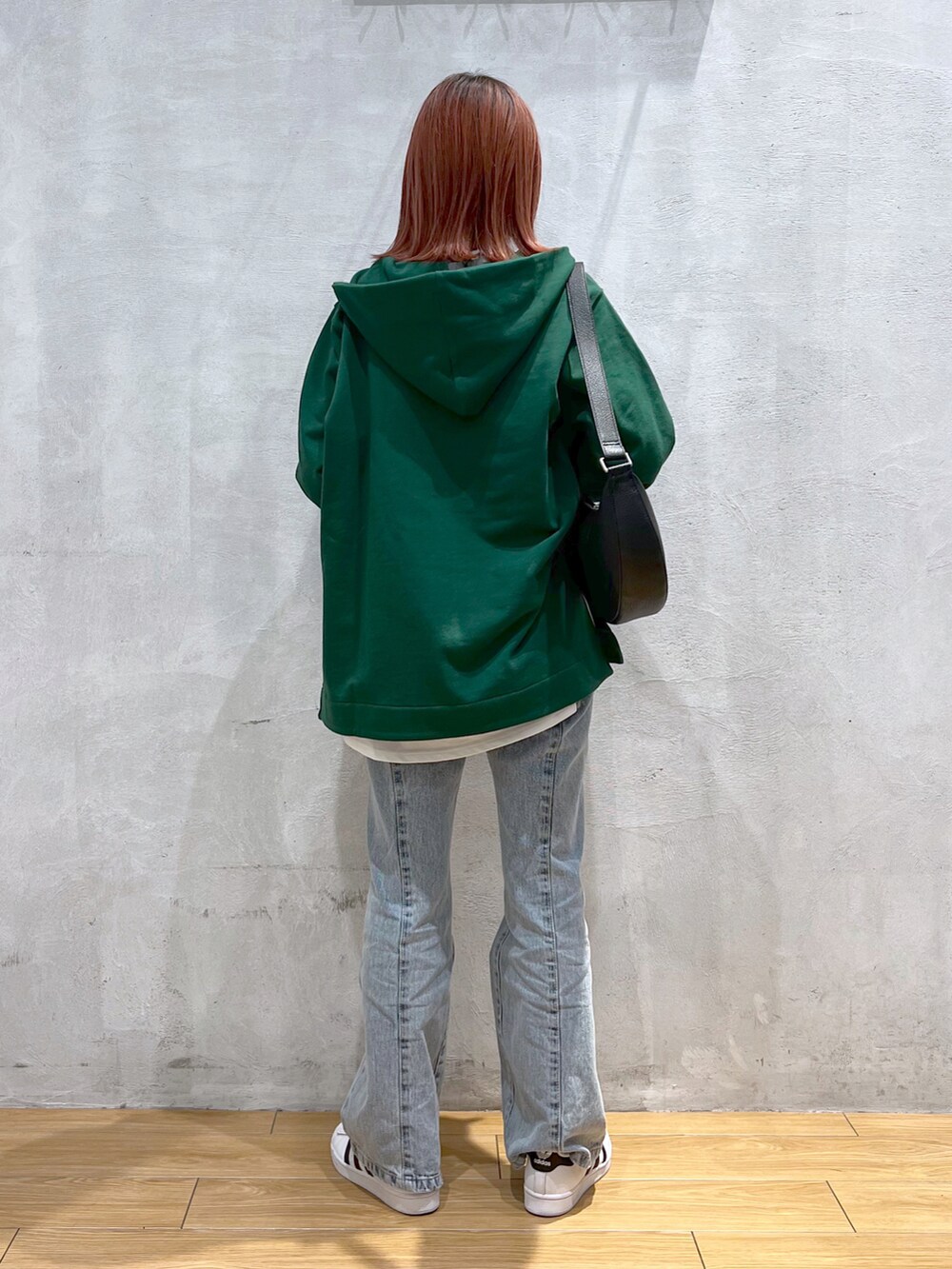 ブルー系のデニムパンツ、グリーン系のスウェット、ホワイト系のTシャツ/カットソーを着用したレディースの冬コーディネートの2枚目の写真