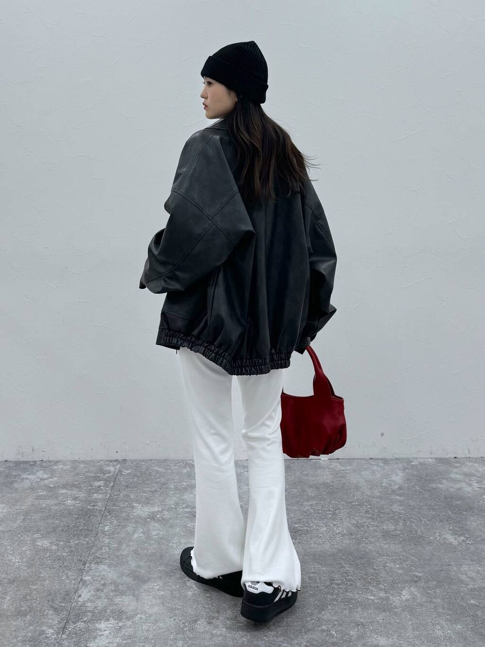 ブラック系のブルゾン、レッド系のハンドバッグ、ベージュ系のその他パンツを着用したレディースの冬コーディネートの2枚目の写真