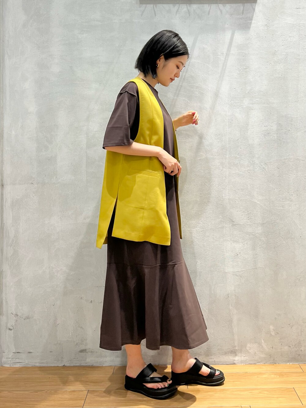 ブラック系のサンダル、ブラウン系のワンピース、イエロー系のその他アウターを着用したレディースの夏コーディネートの2枚目の写真