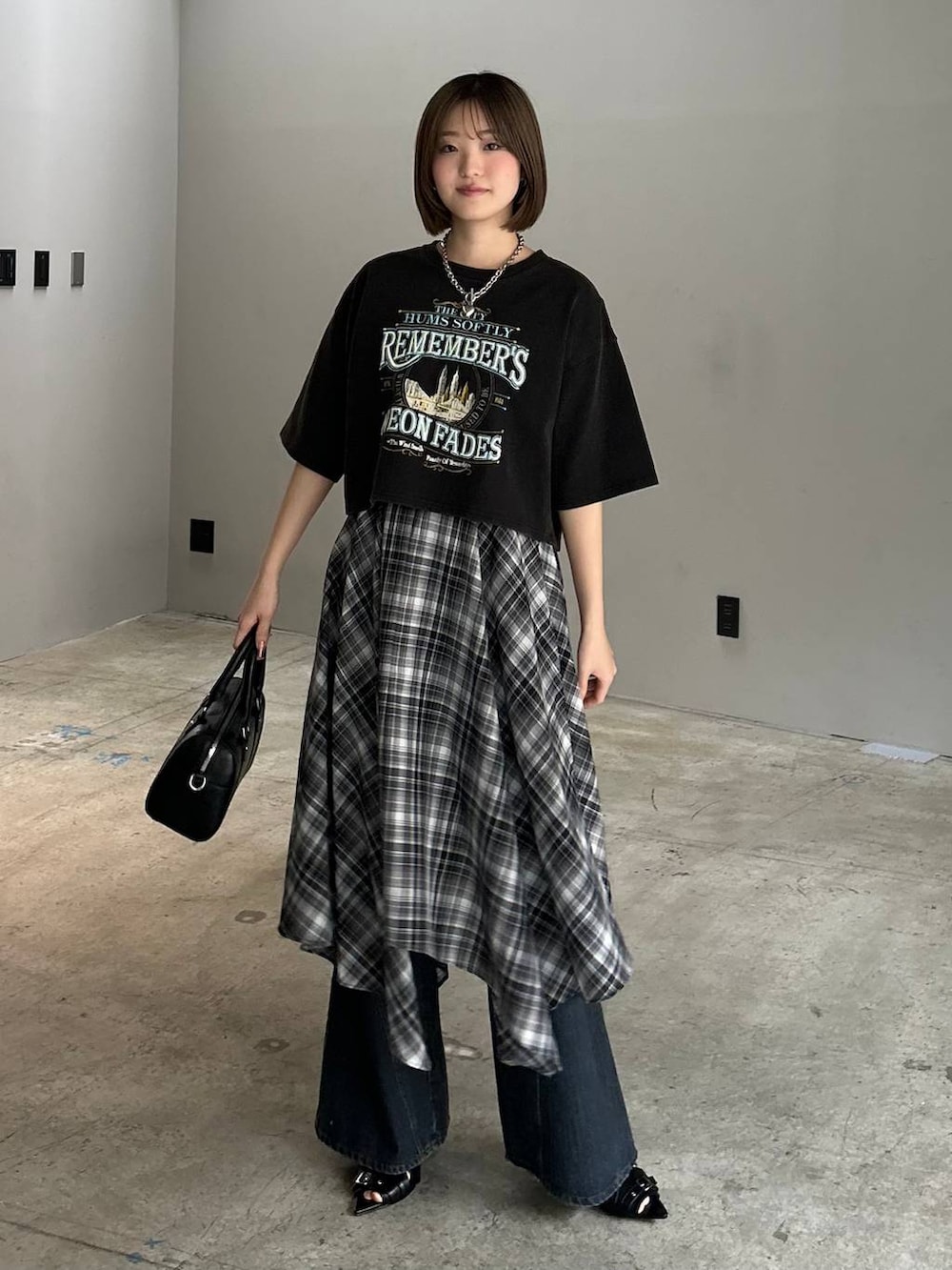 ブルー系のデニムパンツ、ブラック系のボストンバッグ、ブラック系のサンダルを着用したレディースの春コーディネートの4枚目の写真