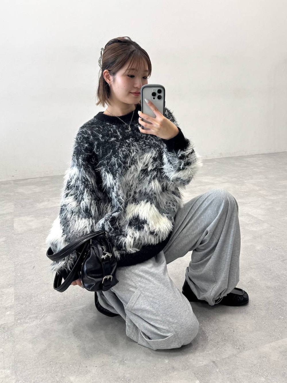 ブラック系のニット/セーター、グレー系のスウェットパンツ、ブラック系のローファーを着用したレディースの夏コーディネートの6枚目の写真