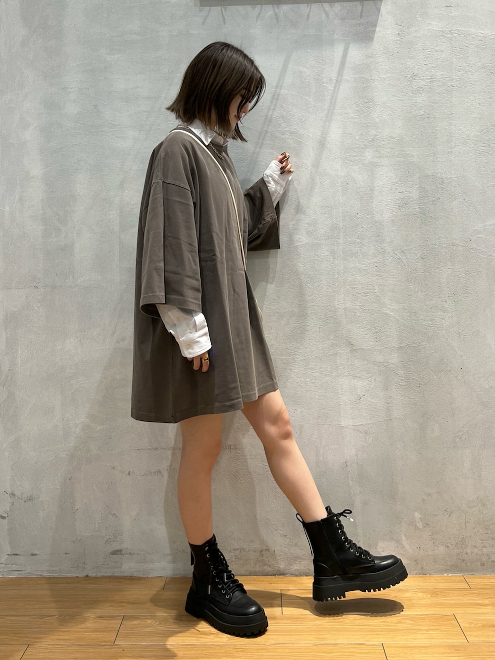 ブラウン系のTシャツ/カットソー、ブラック系のブーツ、ホワイト系のショルダーバッグを着用したレディースの秋コーディネートの3枚目の写真