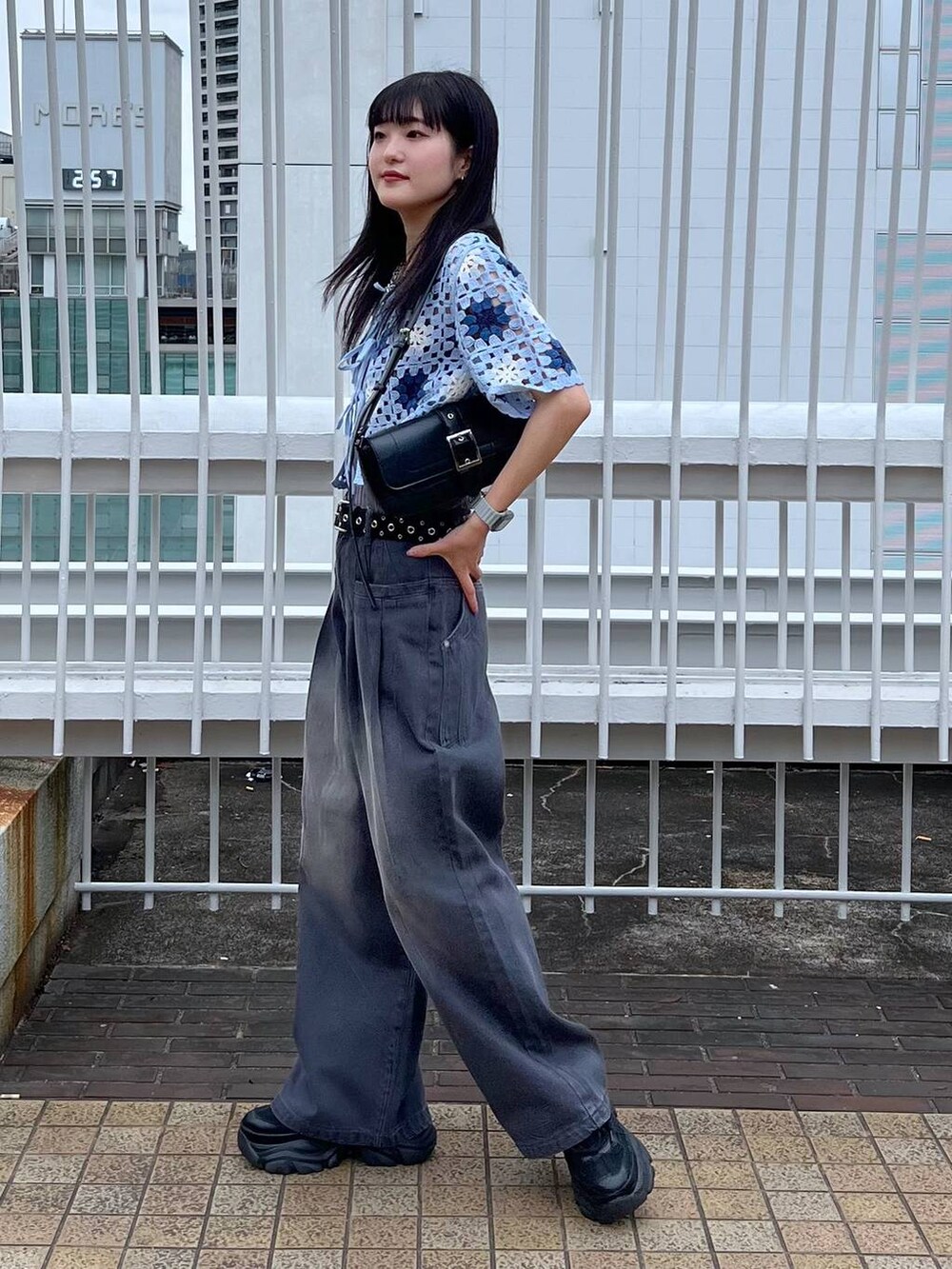 グレー系のタンクトップ、ブラック系のスニーカー、ブラック系のハンドバッグを着用したレディースの夏コーディネートの5枚目の写真