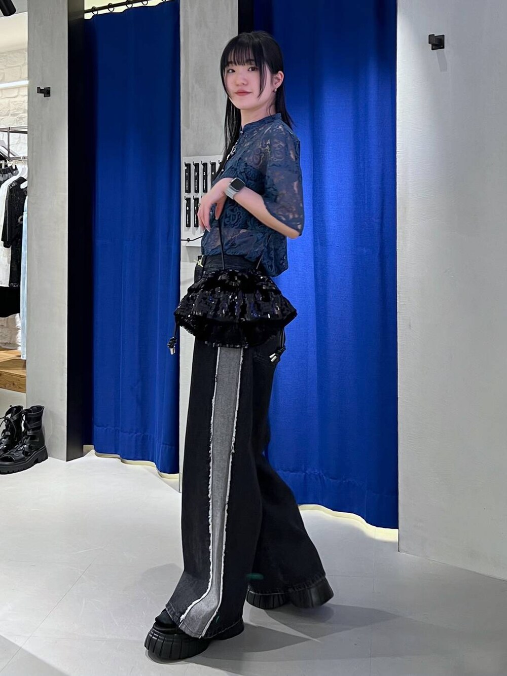 ブラック系のスニーカー、ブルー系のシャツ/ブラウス、ブラック系のキャミソールを着用したレディースの春コーディネートの3枚目の写真