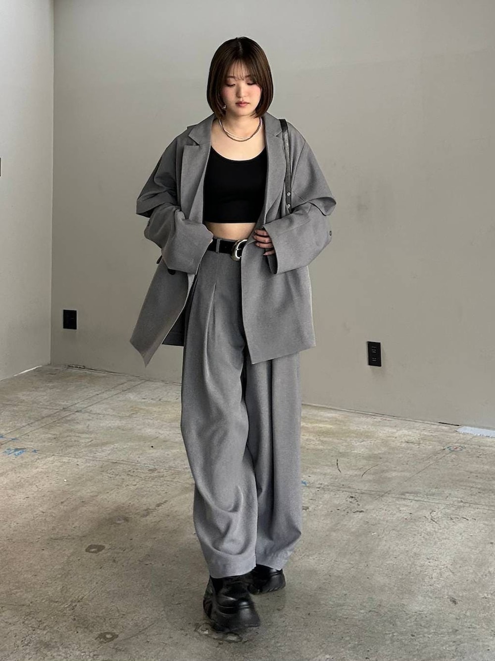 ブラック系のブーツ、ブラック系のキャミソール、ブラック系のハンドバッグを着用したレディースの春コーディネートの7枚目の写真