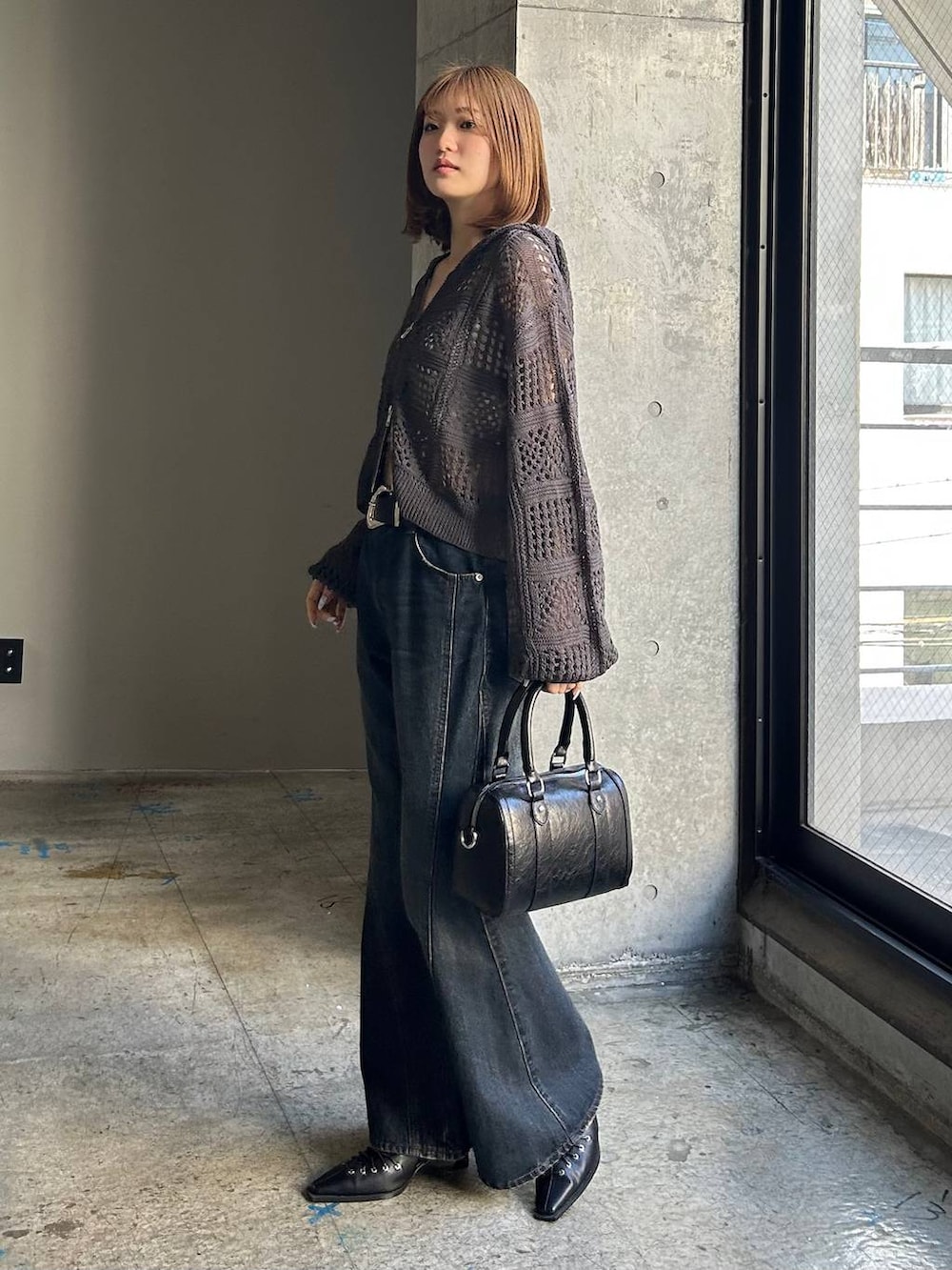 ブルー系のデニムパンツ、ブラック系のボストンバッグ、ブラック系のサンダルを着用したレディースの冬コーディネートの2枚目の写真