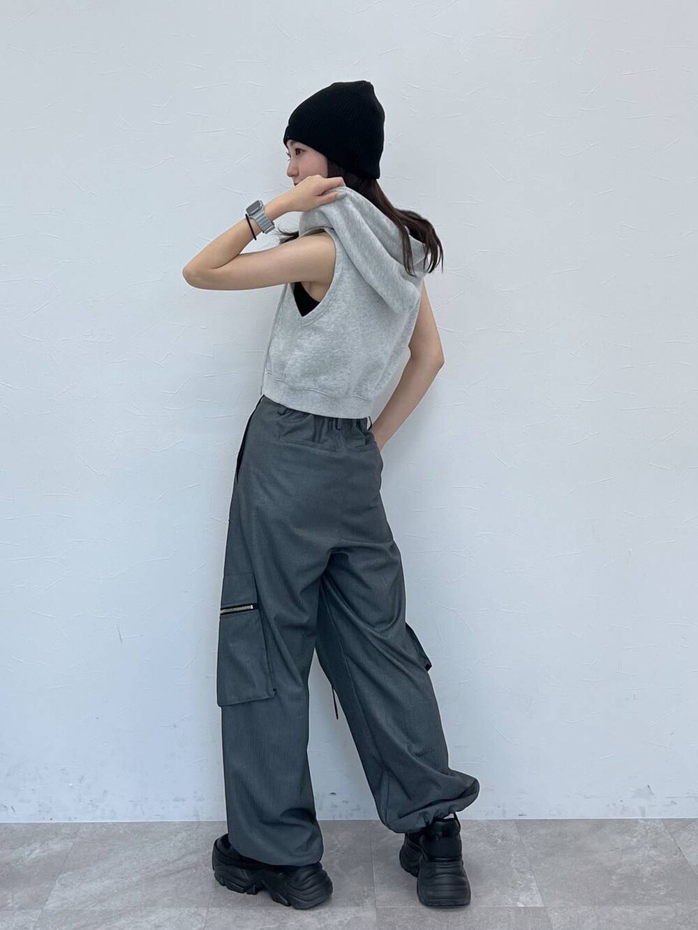 ブラック系のスニーカー、ブラック系のキャミソール、グレー系のパーカーを着用したレディースの春コーディネートの3枚目の写真