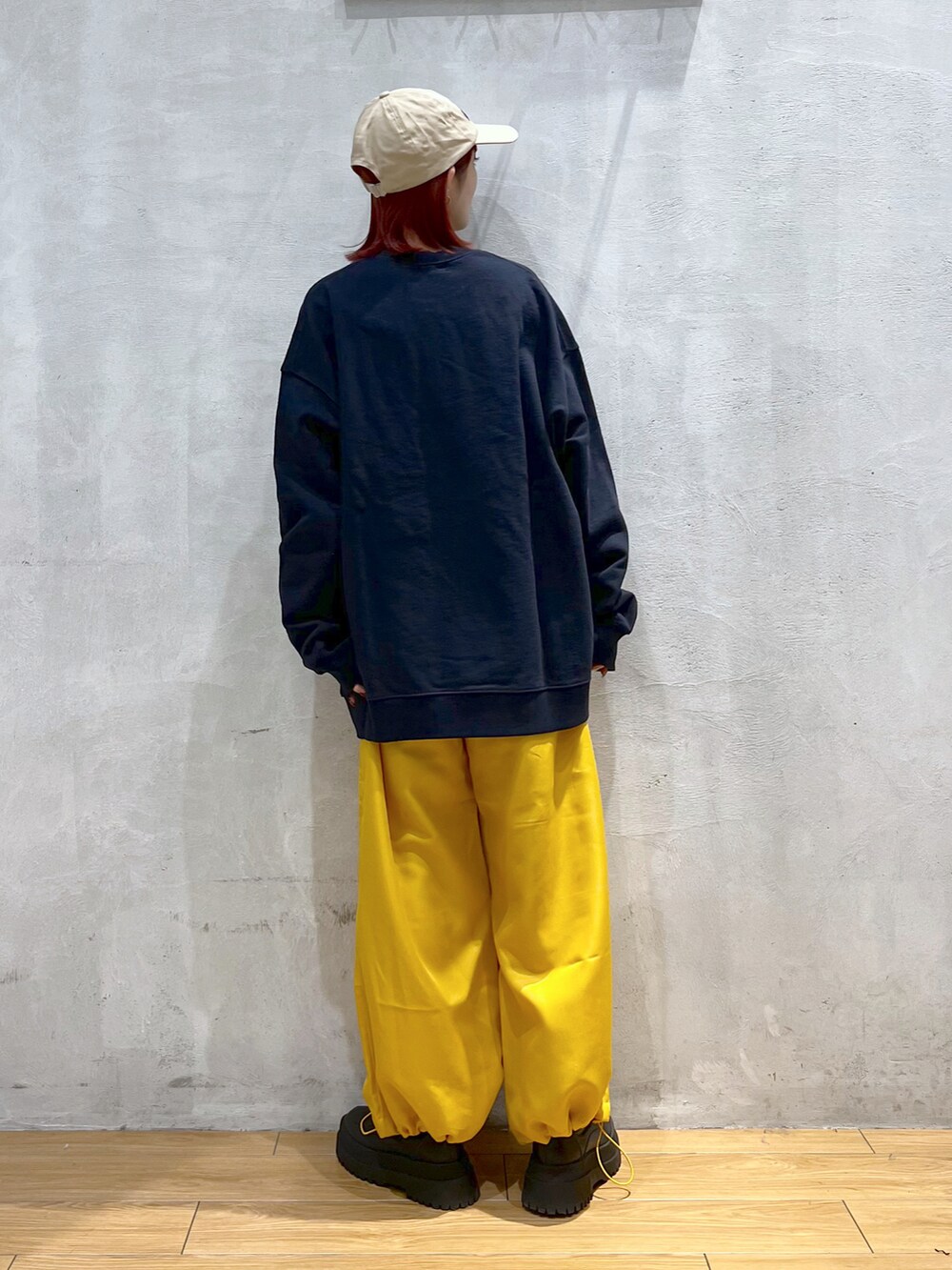 ブルー系のスウェット、イエロー系のその他パンツ、ブラック系のブーツを着用したレディースの冬コーディネートの2枚目の写真