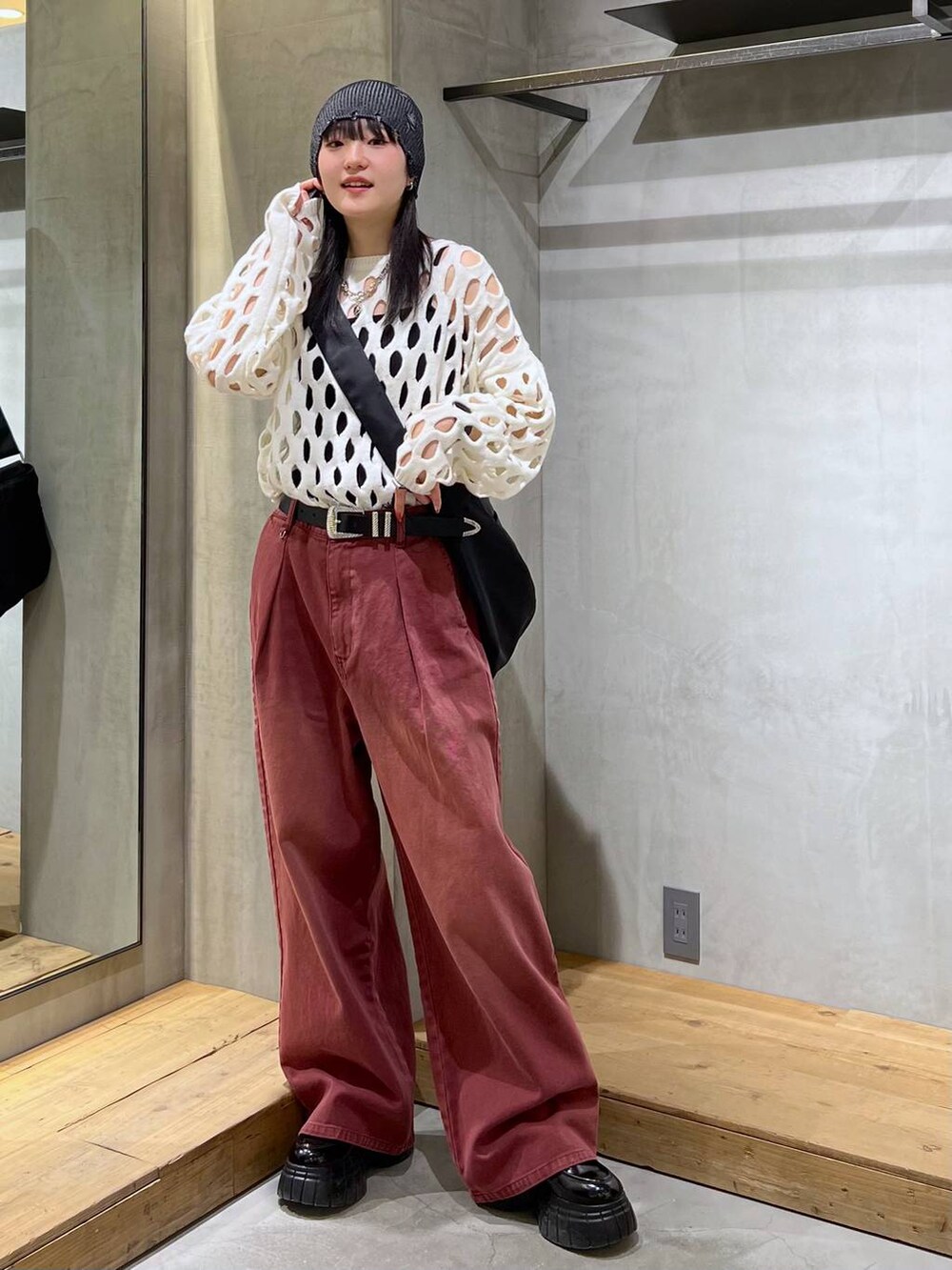 レッド系のデニムパンツ、ブラック系のローファー、ホワイト系のニット/セーターを着用したレディースの冬コーディネートの3枚目の写真