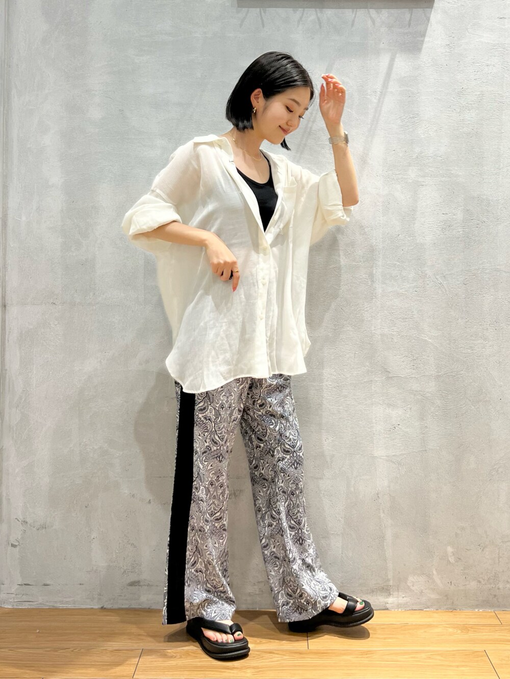 ホワイト系のその他パンツ、ブラック系のサンダル、ホワイト系のシャツ/ブラウスを着用したレディースの夏コーディネートの2枚目の写真