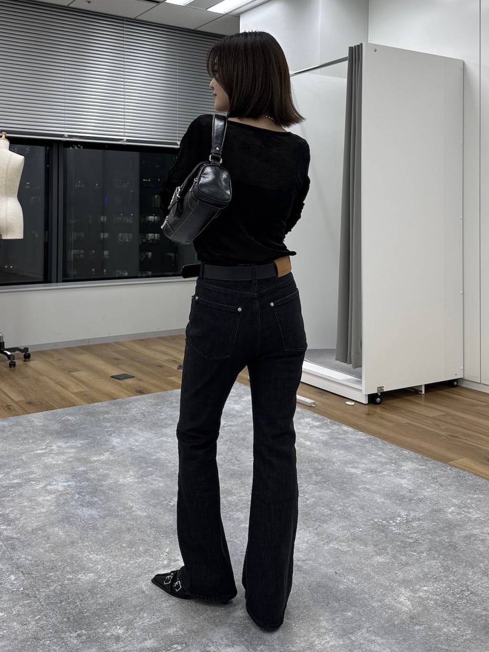 ブラック系のTシャツ/カットソー、ブルー系のデニムパンツ、ブラック系のショルダーバッグを着用したレディースの秋コーディネートの4枚目の写真