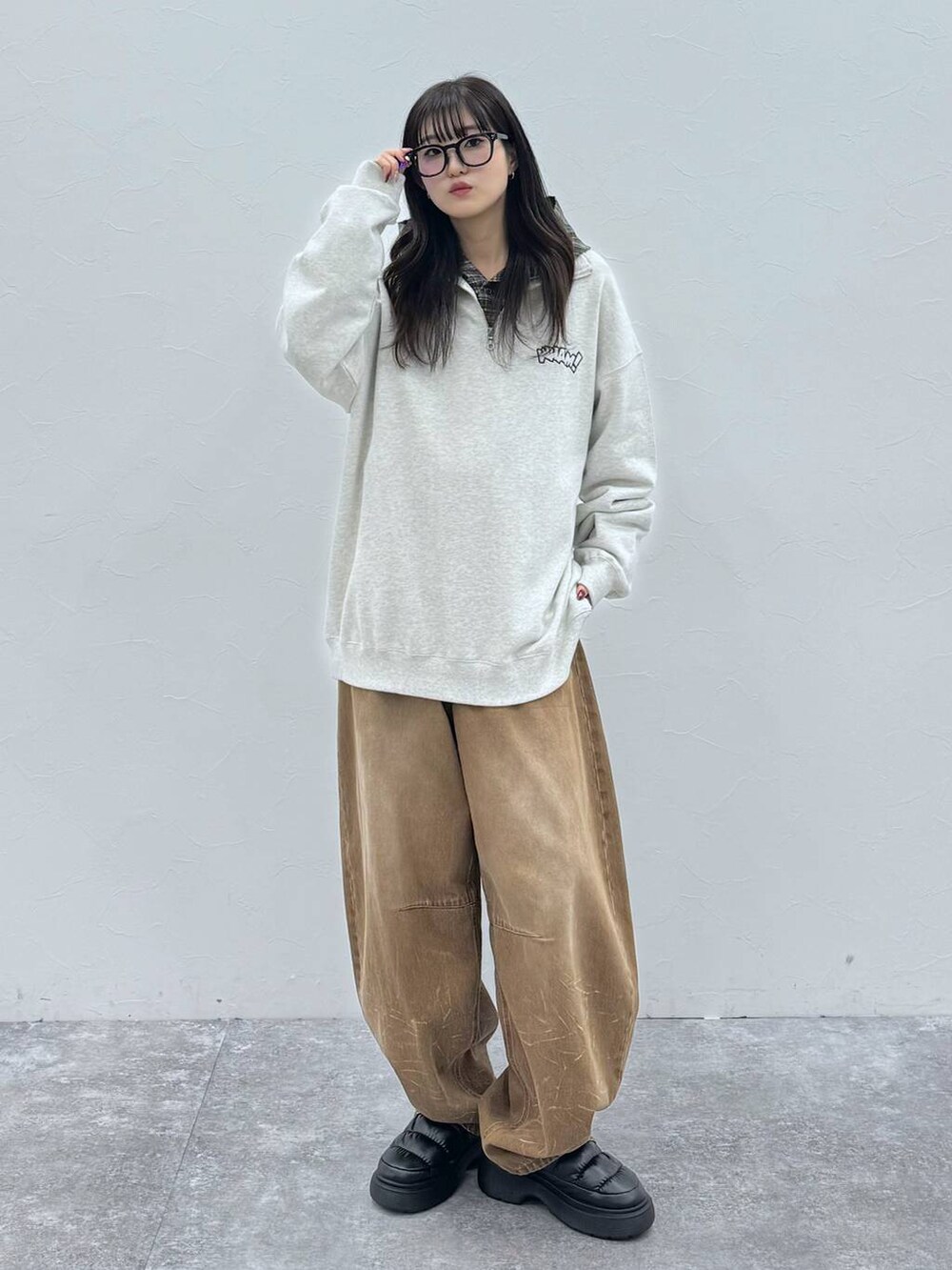 ブラック系のスリッポン、ベージュ系のデニムパンツ、グレー系のスウェットを着用したレディースの冬コーディネートの4枚目の写真
