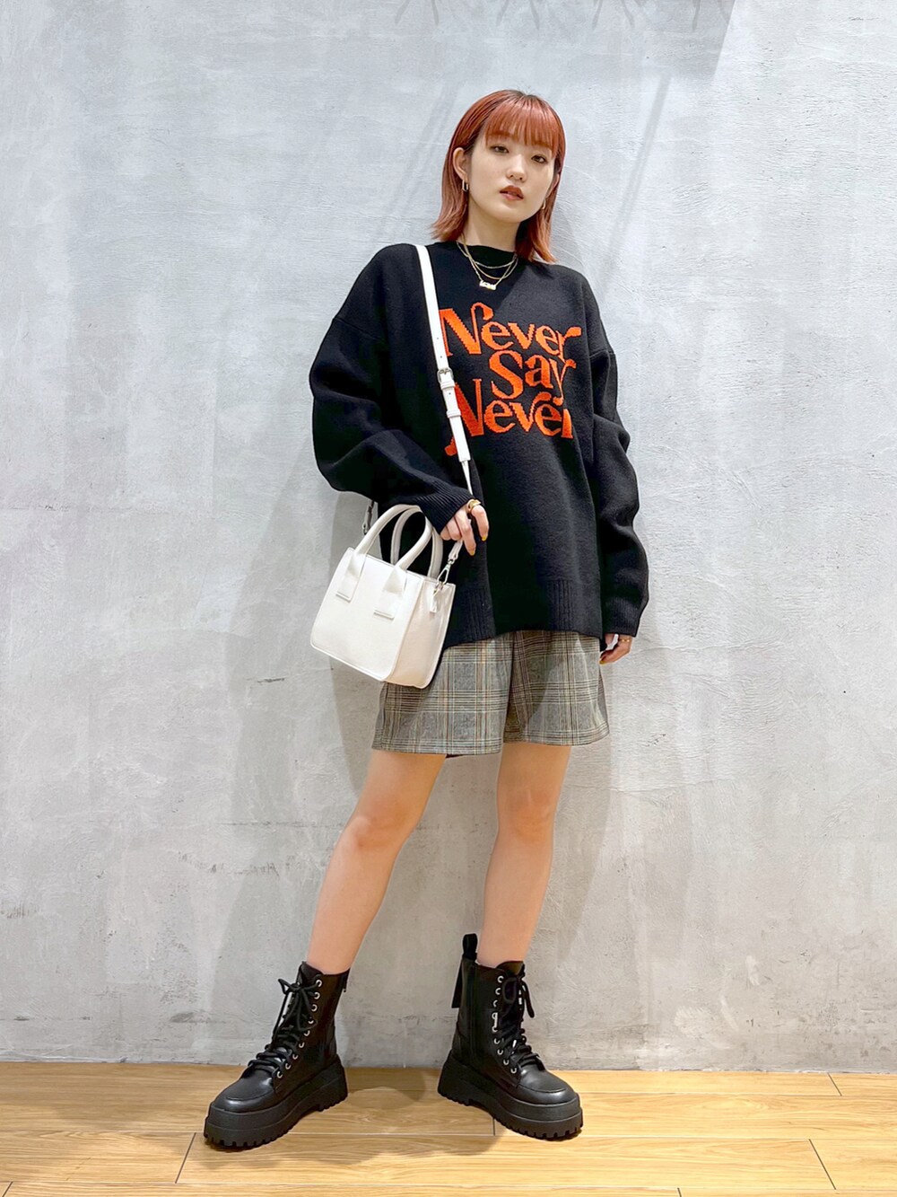 ブラック系のニット/セーター、グレー系のその他パンツ、ホワイト系のショルダーバッグを着用したレディースの冬コーディネートの2枚目の写真