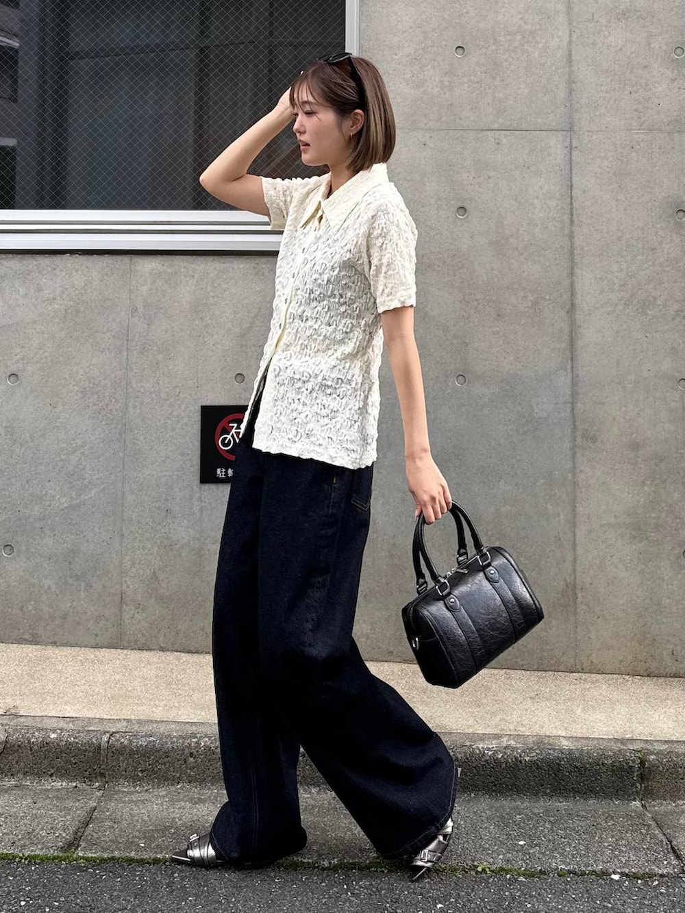 ブルー系のデニムパンツ、ブラック系のボストンバッグ、その他のサンダルを着用したレディースの春コーディネートの4枚目の写真