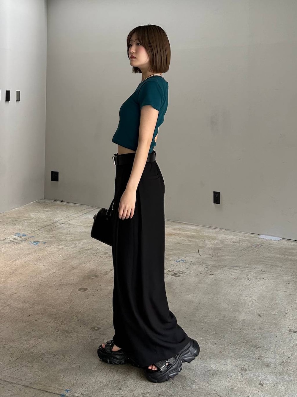 ブラック系のボストンバッグ、ブラック系のサンダル、ブラック系のスラックスを着用したレディースの春コーディネートの2枚目の写真