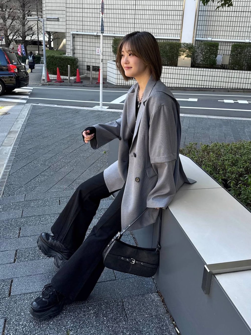 ブラック系のスニーカー、ブラック系のデニムパンツ、ブラック系のハンドバッグを着用したレディースの春コーディネートの6枚目の写真