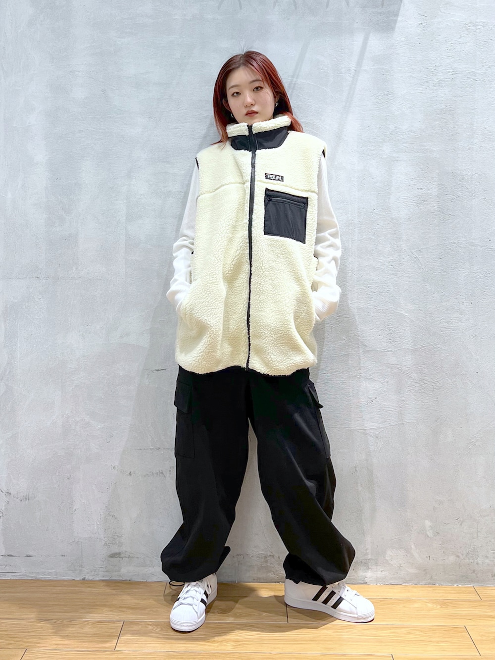 ブラック系のカーゴパンツ、ホワイト系のTシャツ/カットソー、ホワイト系のベストを着用したレディースの冬コーディネートの2枚目の写真