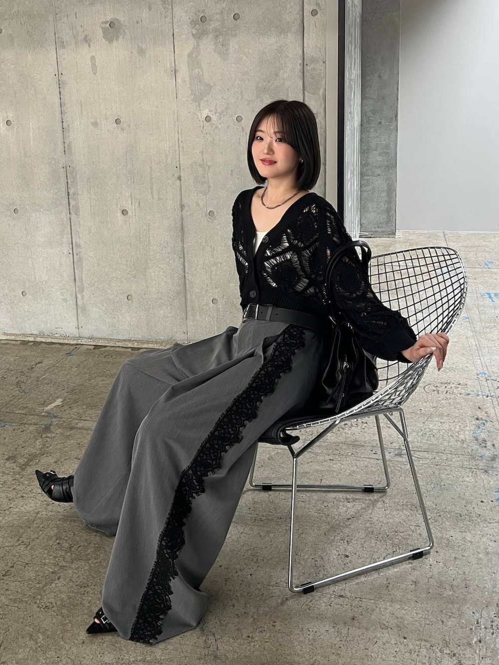 ホワイト系のキャミソール、ブラック系のカーディガン/ボレロ、ブラック系のサンダルを着用したレディースの春コーディネートの6枚目の写真