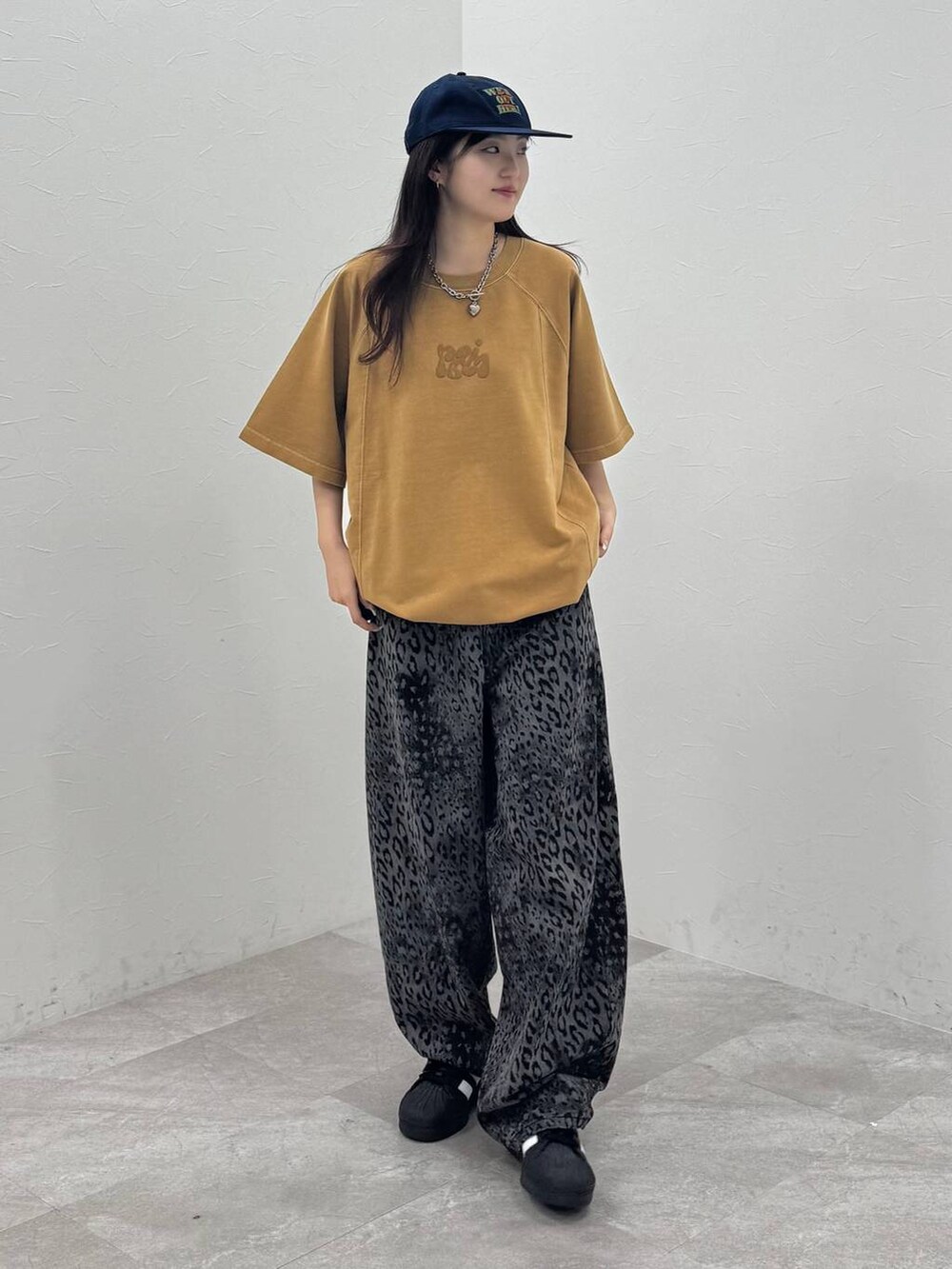 ブラック系のデニムパンツ、イエロー系のTシャツ/カットソー、ブルー系のキャップを着用したレディースの春コーディネートの2枚目の写真