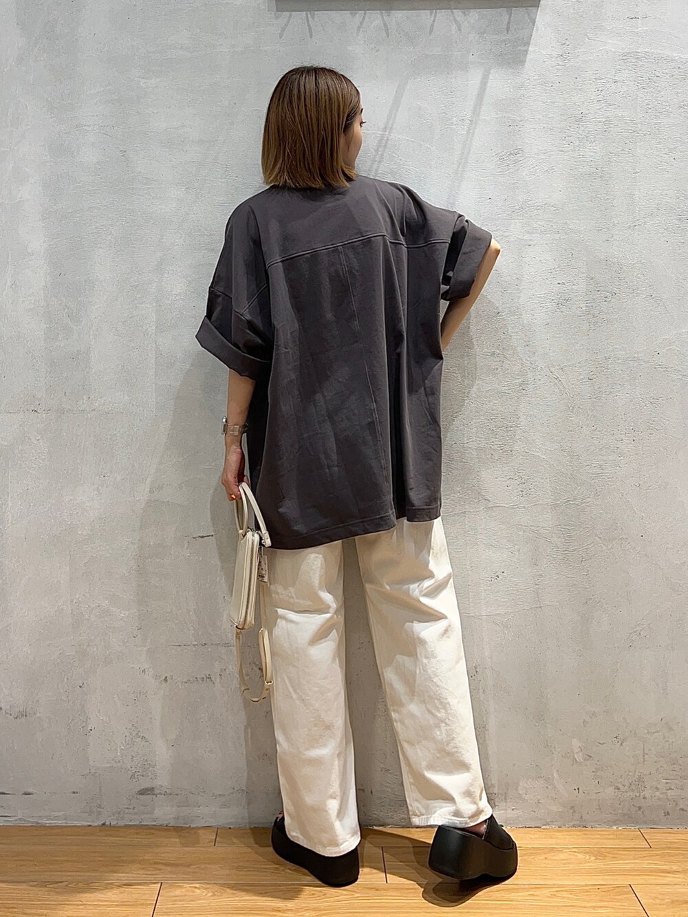 グレー系のTシャツ/カットソー、ホワイト系のデニムパンツ、ホワイト系のショルダーバッグを着用したレディースの夏コーディネートの3枚目の写真