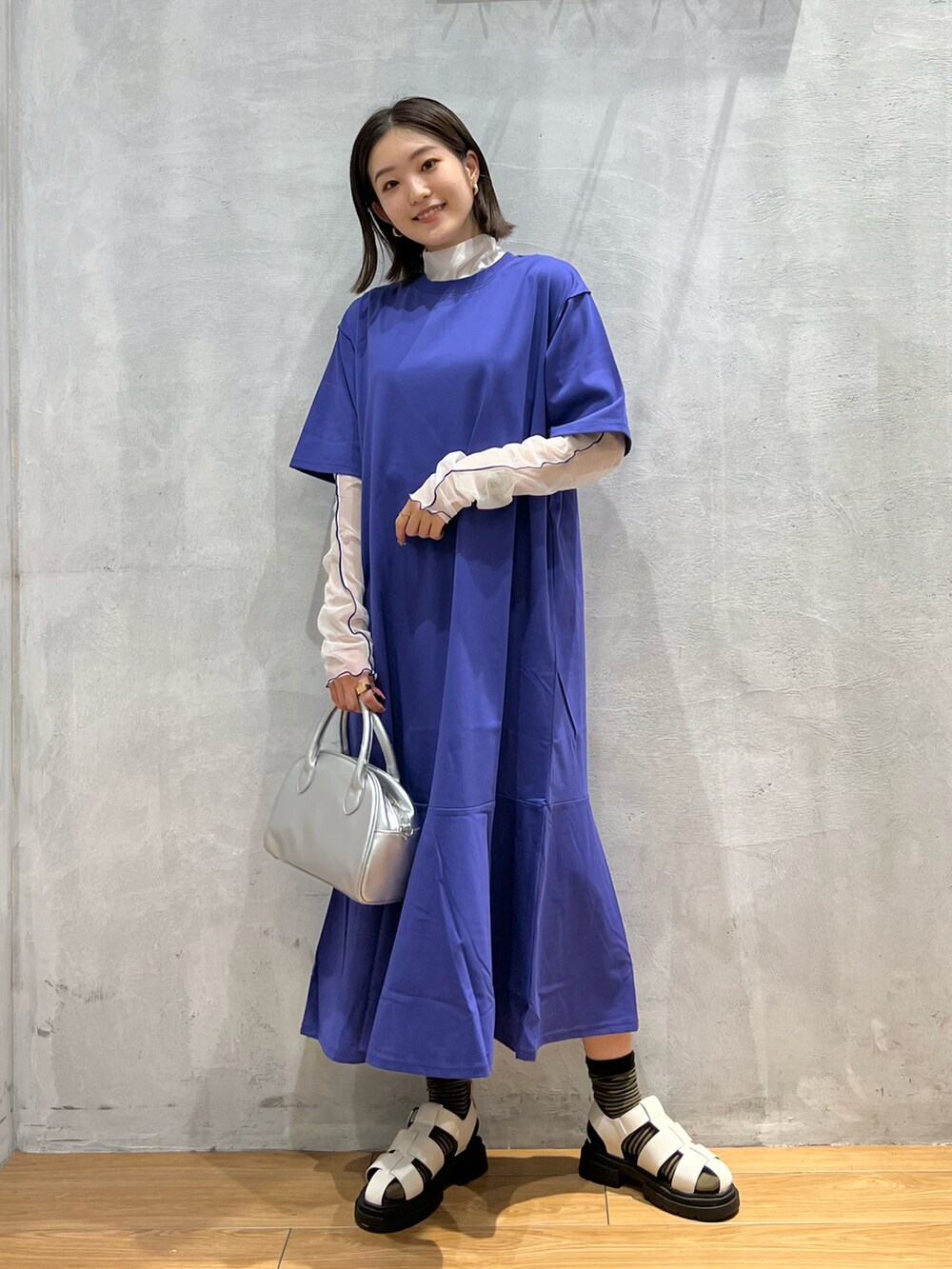 ブルー系のワンピース、ホワイト系のサンダル、シルバー系のショルダーバッグを着用したレディースの夏コーディネートの4枚目の写真