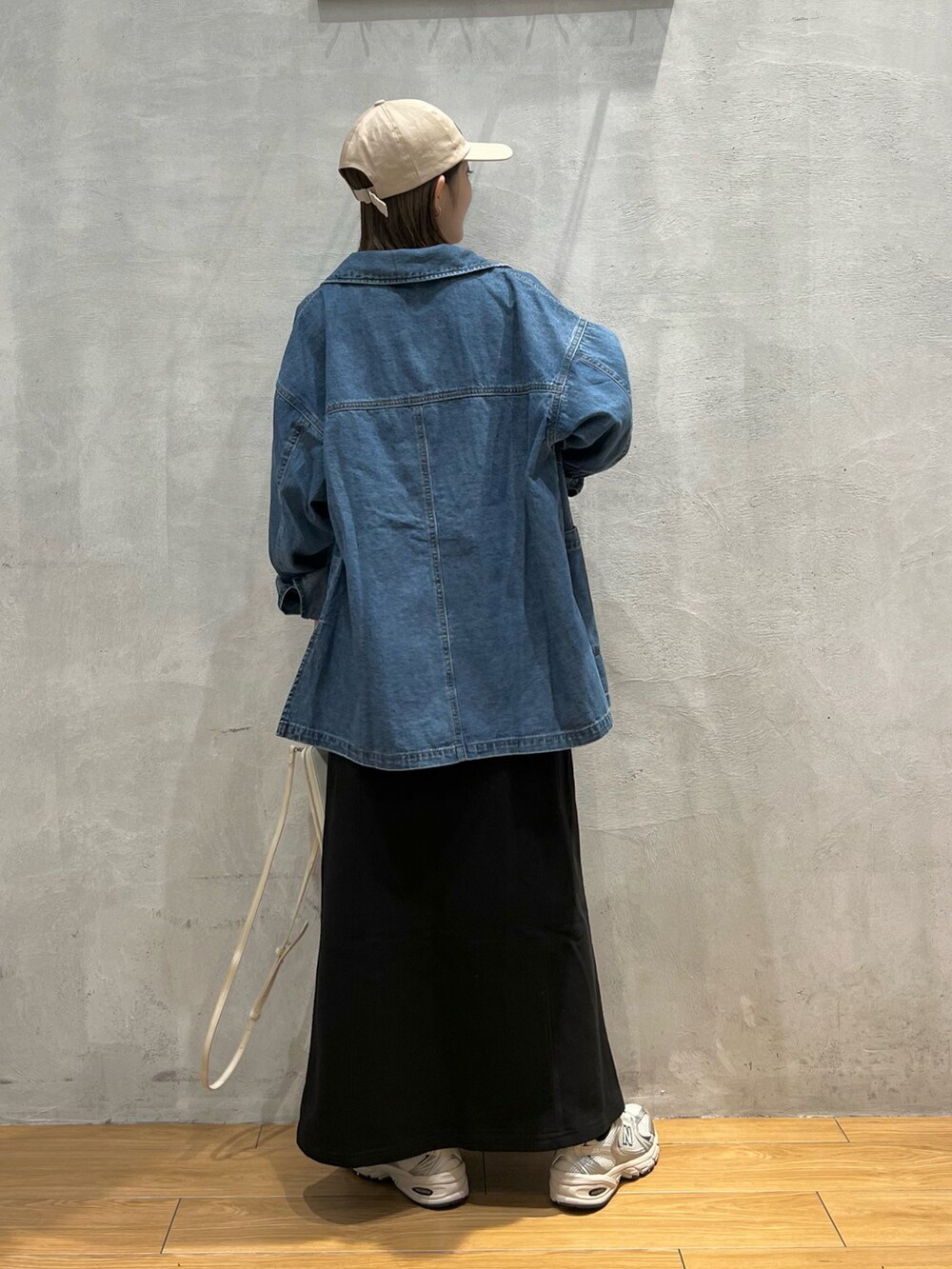 ブルー系のデニムジャケット、ブラック系のキャミソール、ブラック系のスカートを着用したレディースの秋コーディネートの3枚目の写真