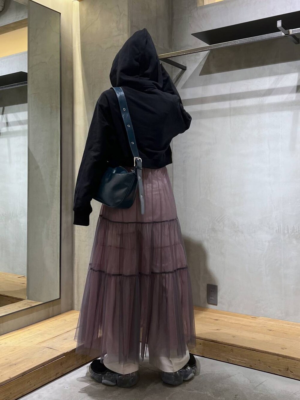 ブラック系のパーカー、ベージュ系のスラックス、グレー系のスカートを着用したレディースの冬コーディネートの4枚目の写真