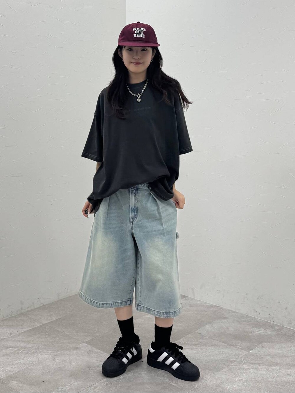 グレー系のTシャツ/カットソー、ブルー系のその他パンツ、レッド系のキャップを着用したレディースの春コーディネートの2枚目の写真