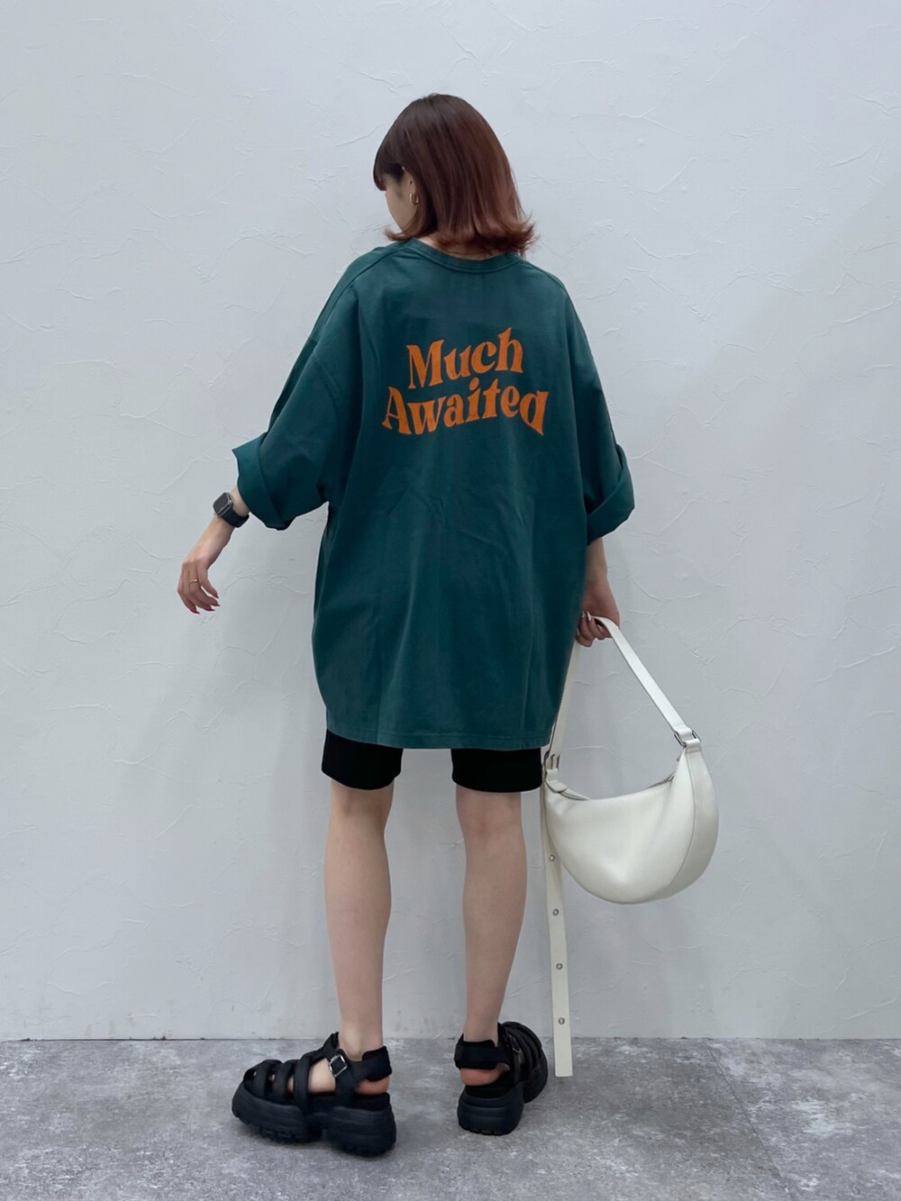 ブラック系のサンダル、グリーン系のTシャツ/カットソー、ホワイト系のショルダーバッグを着用したレディースの春コーディネートの2枚目の写真