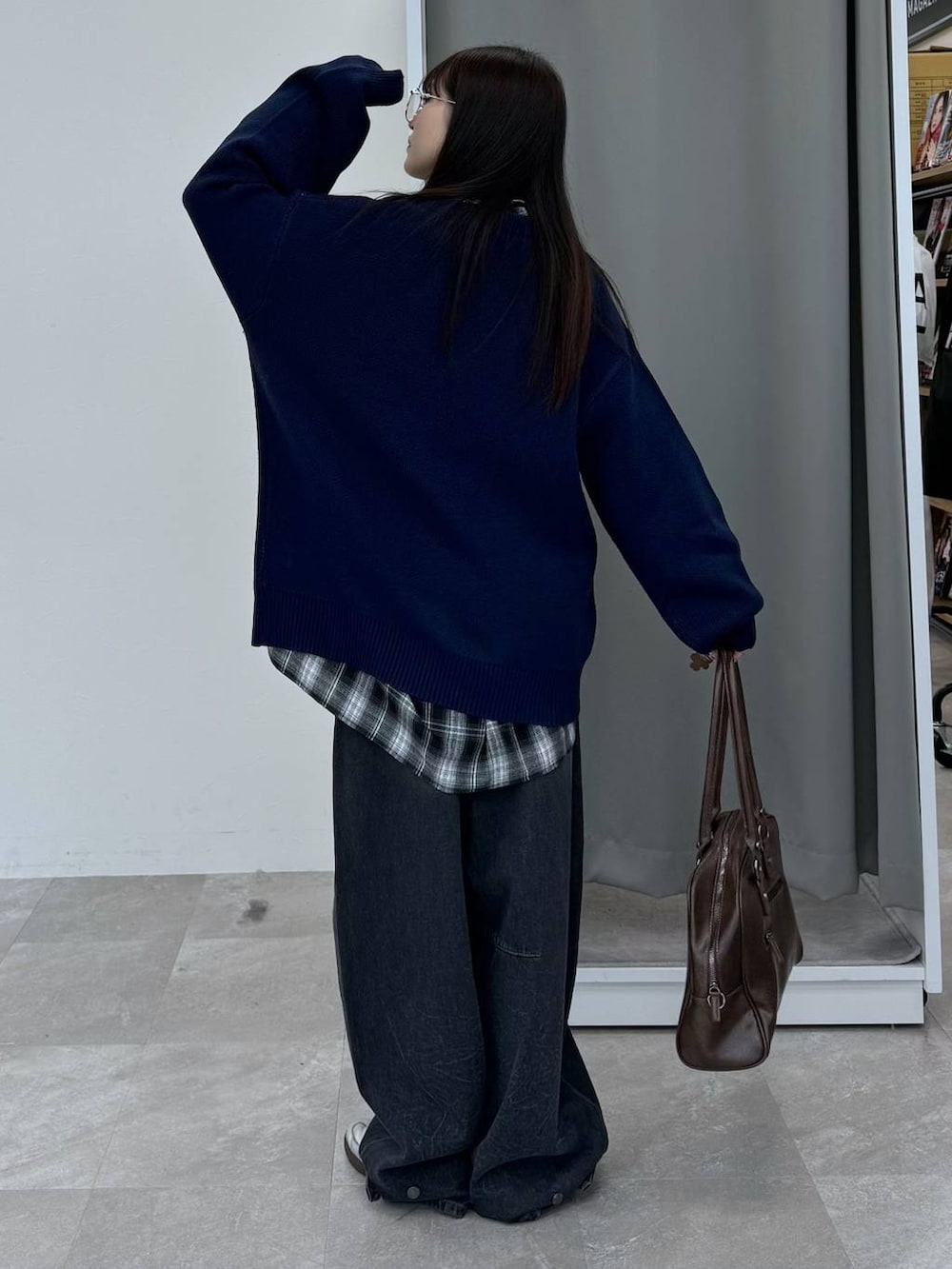 ブルー系のニット/セーター、ブラウン系のボストンバッグ、ブラック系のデニムパンツを着用したレディースの冬コーディネートの4枚目の写真