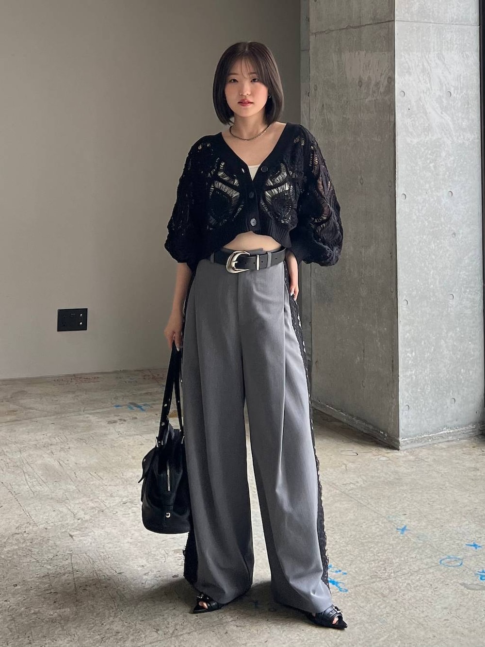 ホワイト系のキャミソール、ブラック系のカーディガン/ボレロ、ブラック系のサンダルを着用したレディースの春コーディネートの3枚目の写真