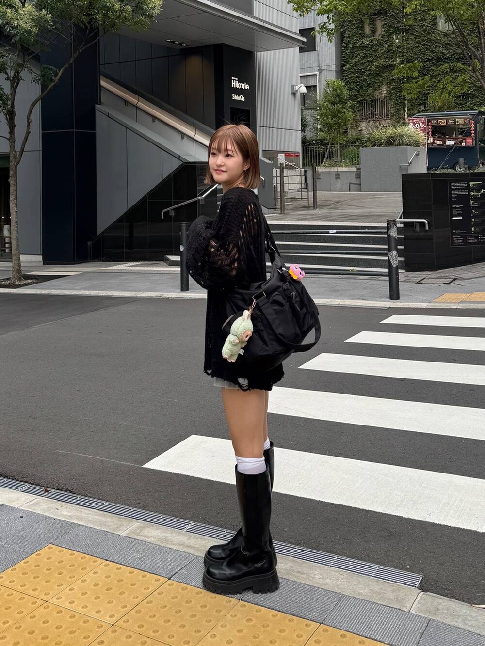 ブラック系のボストンバッグ、ブラック系のニット/セーター、ブラック系のブーツを着用したレディースの秋コーディネートの2枚目の写真