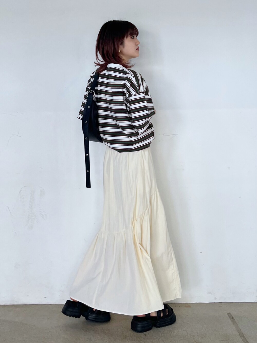 ブラック系のショルダーバッグ、ホワイト系のTシャツ/カットソー、ブラック系のサンダルを着用したレディースの春コーディネートの3枚目の写真