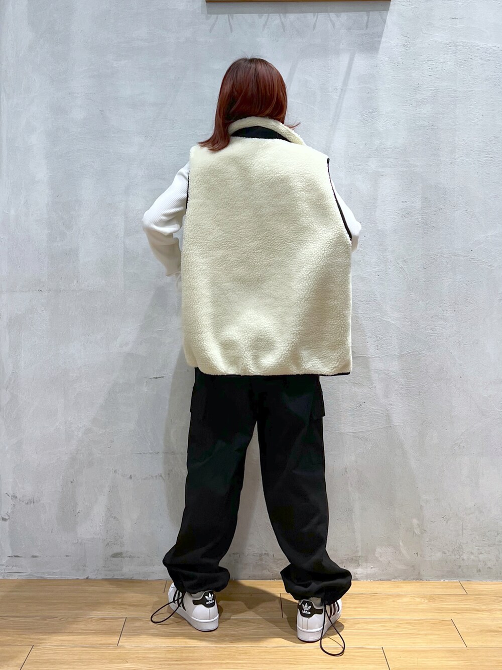 ブラック系のカーゴパンツ、ホワイト系のTシャツ/カットソー、ホワイト系のベストを着用したレディースの冬コーディネートの3枚目の写真