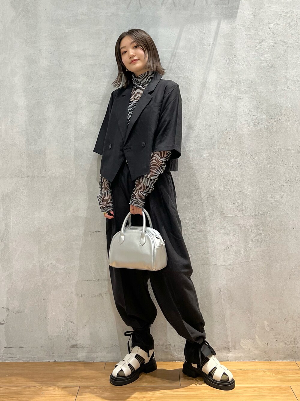 シルバー系のショルダーバッグ、ホワイト系のTシャツ/カットソー、ブラック系のテーラードジャケットを着用したレディースの夏コーディネートの3枚目の写真