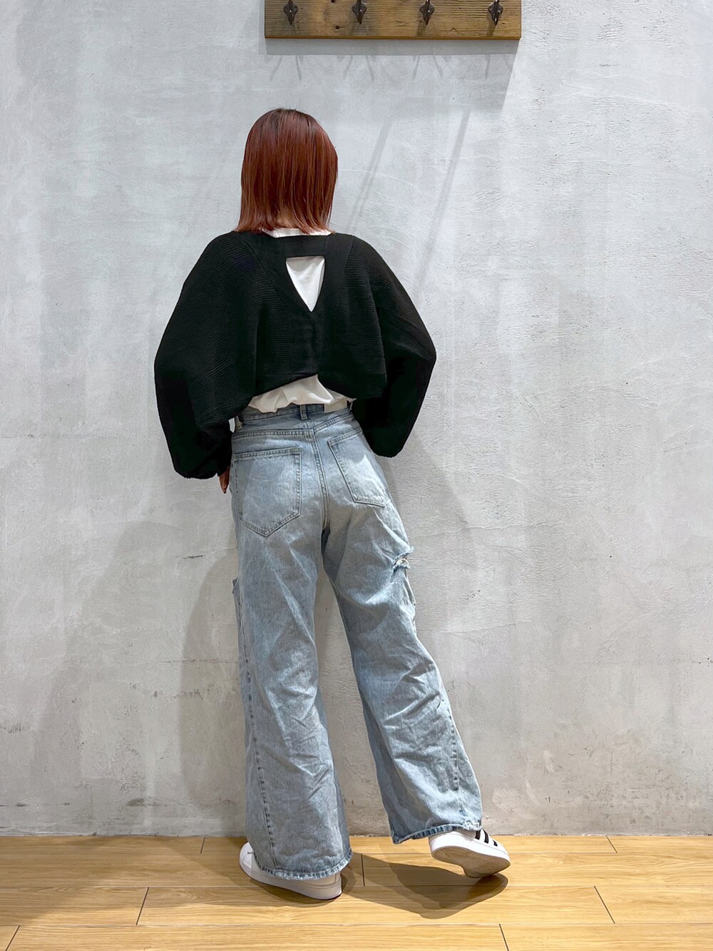 ブルー系のデニムパンツ、ブラック系のニット/セーター、ホワイト系のTシャツ/カットソーを着用したレディースの冬コーディネートの2枚目の写真