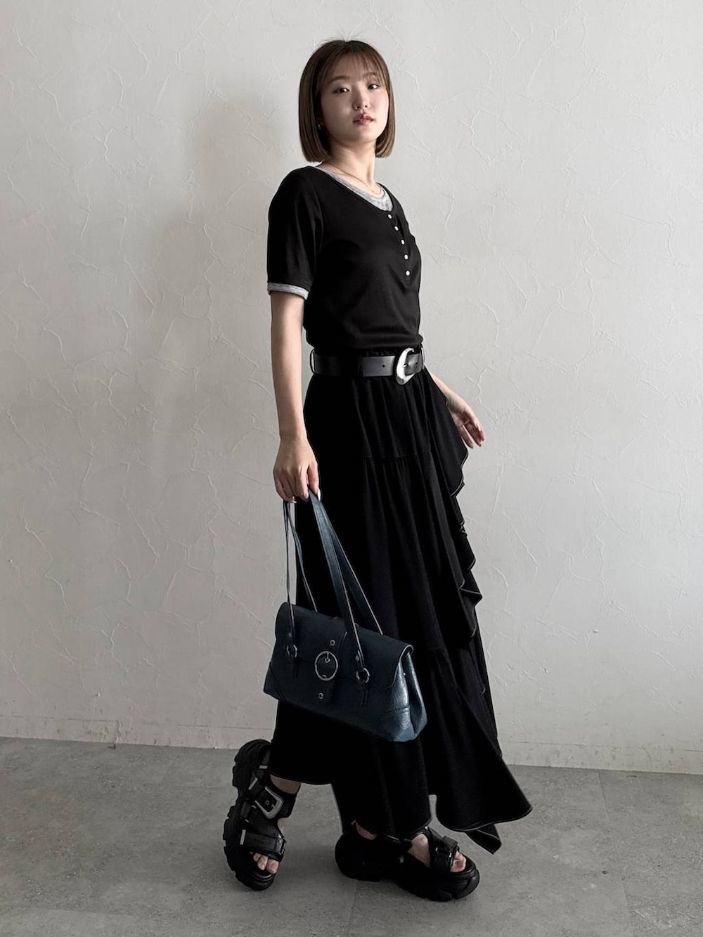 ブラック系のスカート、ブラック系のサンダル、ブラック系のTシャツ/カットソーを着用したレディースの夏コーディネートの3枚目の写真